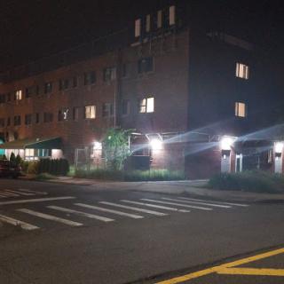 A nighttime view of a building with illuminated windows and street lighting.
