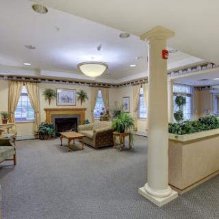 A cozy lobby area featuring comfortable seating, decorative plants, and warm lighting.