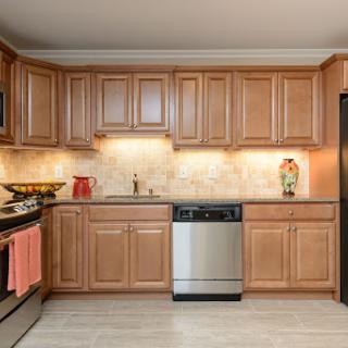 A modern kitchen featuring wooden cabinets, stainless steel appliances, and a stylish tile backsplash.