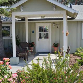 A charming house with a small porch and vibrant garden.