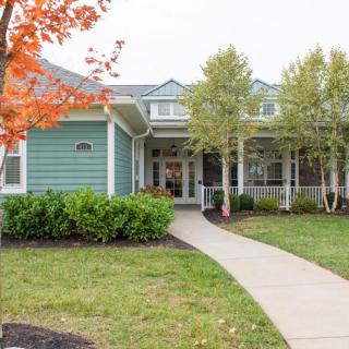 A charming residential house with a welcoming front porch and landscaped yard.