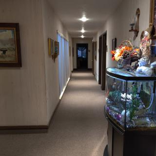 A well-lit indoor hallway featuring a decorative fish tank and artwork on the walls.