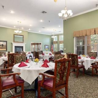 An elegant dining room with neatly arranged tables and chairs, adorned with tablecloths and decorative elements.
