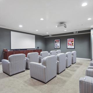 A home theater room with comfortable seating and a large screen.