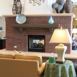 A cozy living room with a brick fireplace, sofa, and decorative elements.