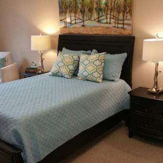A cozy bedroom with a neatly made bed, soft lighting, and stylish decor.