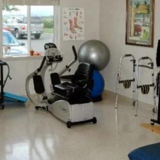 A physical therapy room equipped with various exercise machines and tools for rehabilitation.