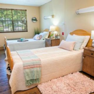A cozy, well-decorated bedroom with two beds and warm lighting.