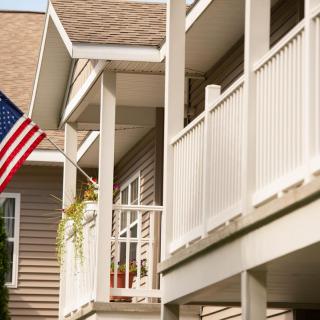 A residential house with an American flag displayed on the porch.