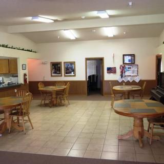 A cozy dining area with wooden tables and chairs, decorated with framed photographs.