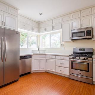 A modern kitchen with stainless steel appliances and white cabinets.