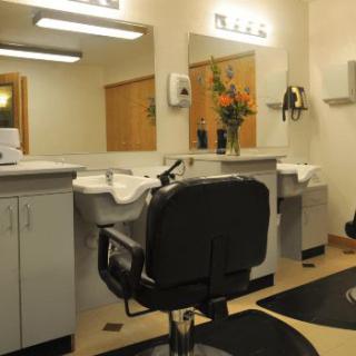 Interior view of a modern barber shop with chairs and mirrors.