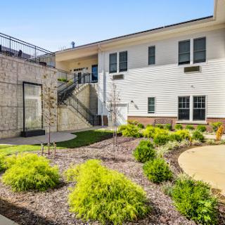 A beautifully landscaped outdoor area featuring modern architecture and vibrant greenery.