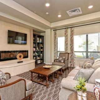 A modern living room with comfortable seating, a coffee table, and a mounted television.