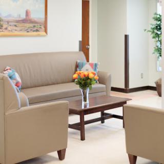 A cozy waiting area featuring comfortable seating and a touch of decorative flowers.