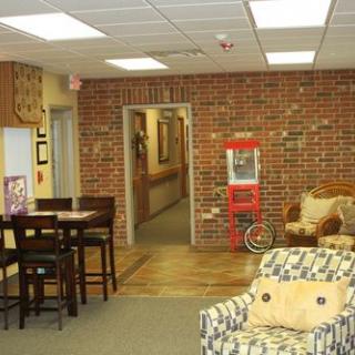 A cozy lobby with seating, a popcorn machine, and brick wall decor.