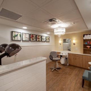 A cozy salon interior with hair drying stations and comfortable seating.