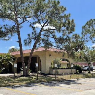 A sunny day showcasing a building surrounded by trees in a residential area.