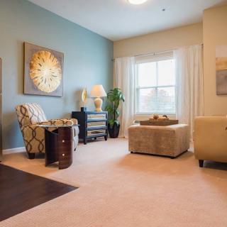 A cozy living room featuring elegant furniture and stylish decor, with natural light streaming in through the window.