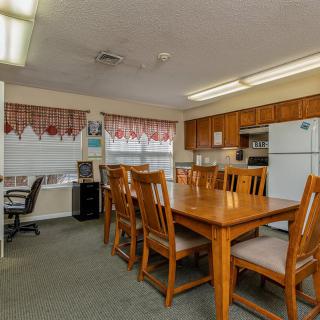 A combined kitchen and dining area with wooden furniture and an office corner.