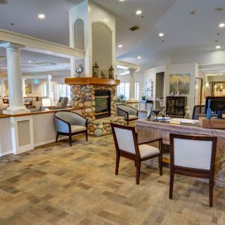 A spacious and elegantly decorated lounge featuring a central fireplace and comfortable seating.