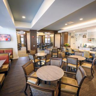 A modern dining area with multiple tables and chairs, featuring elegant lighting and decor.