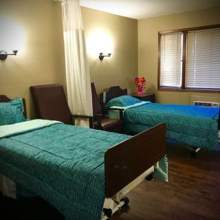 A hospital room with two neatly made beds and comfortable lighting.