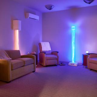 A cozy therapy room with soothing mood lighting and comfortable chairs.