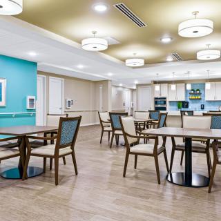 A modern dining area with wooden flooring and contemporary lighting.