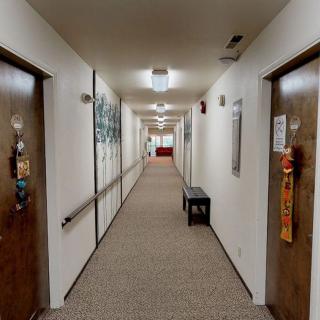 A well-lit hallway with multiple doors and decorations on the walls.
