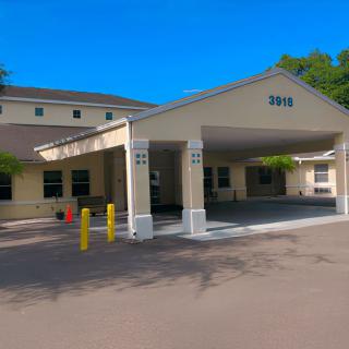 A building entrance with a covered driveway and parking area.