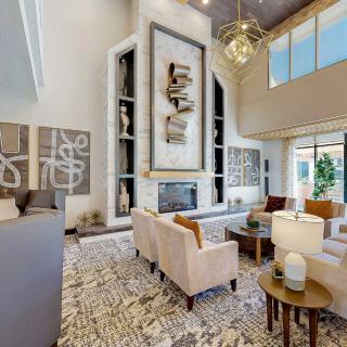 A spacious, modern living room with high ceilings and contemporary decor.
