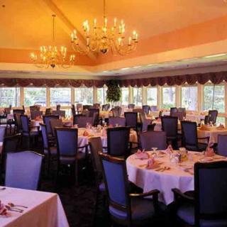 An elegant dining room set with round tables and chandeliers, creating a refined atmosphere.