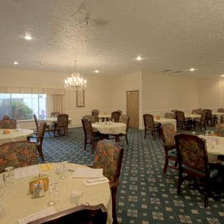 An elegant dining room with multiple tables and ornate chairs arranged neatly.