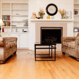 A cozy living room with sofas, a fireplace, and built-in bookshelves.