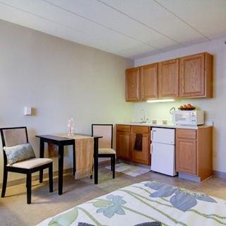 A compact kitchenette with a small dining area in an apartment setting.