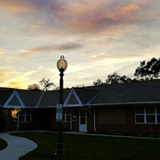 A serene sunset illuminating the pathway between buildings, with a streetlight casting a warm glow.