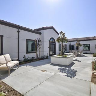 A modern house with a spacious courtyard on a sunny day.