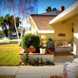 A charming house with a well-kept yard and cozy porch on a sunny day.