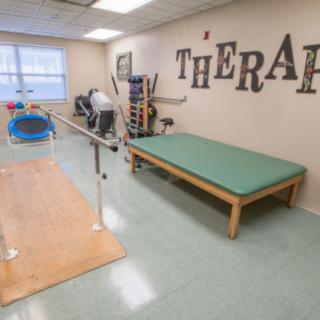 A well-equipped physical therapy room with exercise equipment and treatment areas.