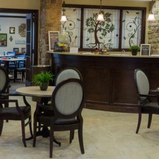 A cozy seating area with elegant furniture and a reception desk featuring stained glass decor.