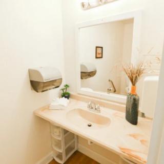 A clean bathroom with a large mirror, sink, and decorative elements.