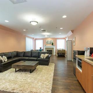 A spacious living room with a large sectional sofa, coffee table, and fireplace.