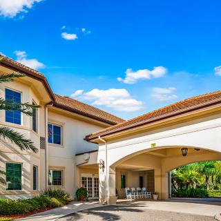 A hospital entrance with a covered driveway under a clear blue sky.