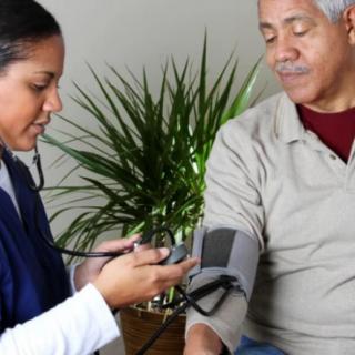A healthcare professional measures a patient's blood pressure.