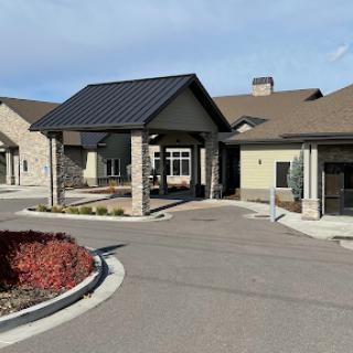 A modern entrance to a residential facility with well-maintained landscaping.