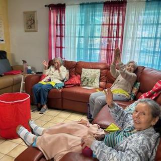 A cozy living room scene featuring a group of elderly individuals enjoying each other's company.