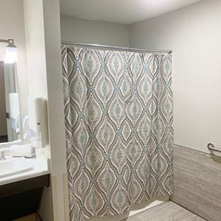 A modern bathroom with a patterned shower curtain and a sleek sink area.