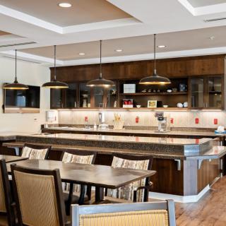 A modern kitchen and dining area with stylish lighting fixtures and comfortable seating.