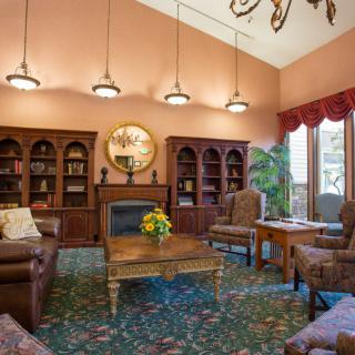 A cozy living room with bookshelves, a fireplace, and comfortable seating.